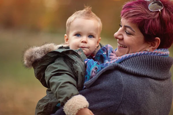 Chłopiec z matką w jesiennym parku ciesząc się razem — Zdjęcie stockowe