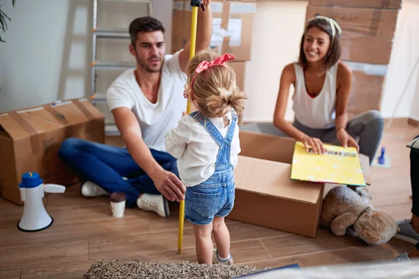 Happy Child med föräldrar flyttar i nya hem uppackning Box — Stockfoto