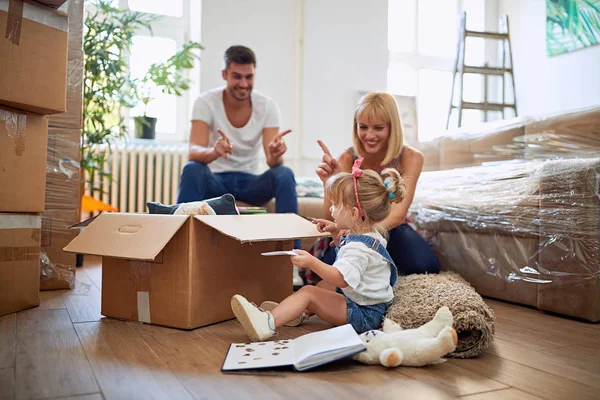 Liten flicka leker med pappkartonger i nytt hem — Stockfoto