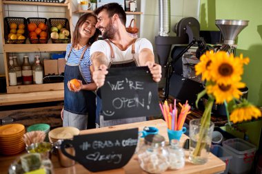 açık tabela gösteren kendi kafe mağazasında sahibi