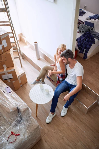 Man and woman sitting on floor and relaxing after cleaning and unpacking — Stock Photo, Image
