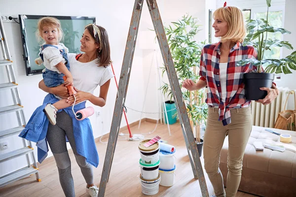 Unga lesbiska föräldrar flyttar i nytt hus med ett småbarn flicka — Stockfoto
