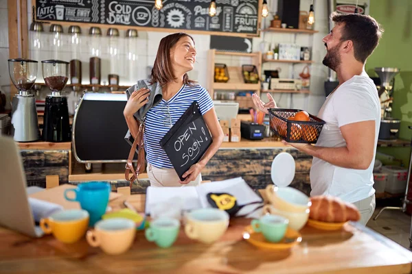 Young man and woman work to open their cafe store — Stock Photo, Image