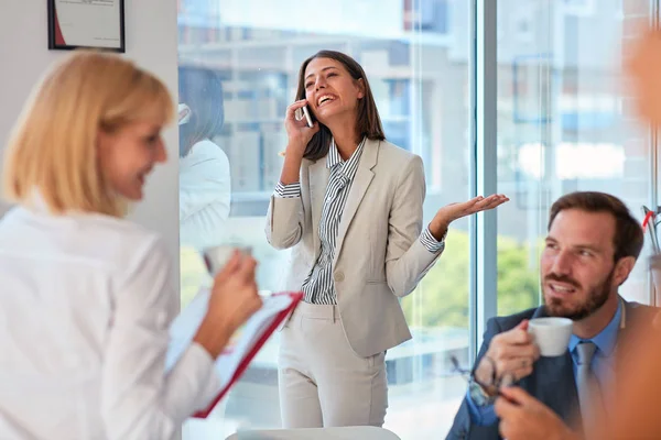 Бізнес-леді розмовляє по телефону в офісі, розмовляючи wi — стокове фото