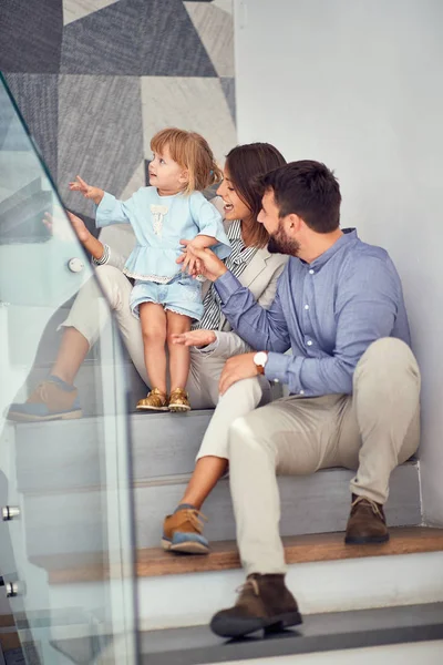 Feliz mujer y hombre disfrutando y divirtiéndose con su chica en la escalera — Foto de Stock