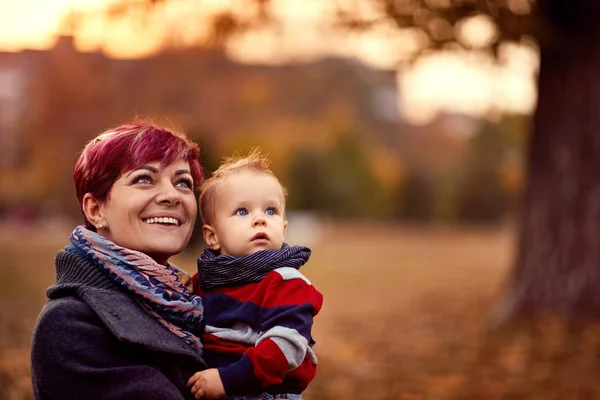 Happy mother with son at the autumn park enjoying together — Stock Photo, Image