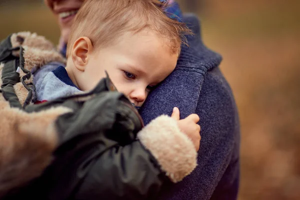 Tired boy with mother at the autumn park together — Stock Photo, Image