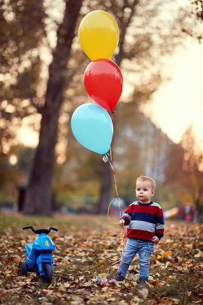Criança caminha no parque com balões — Fotografia de Stock