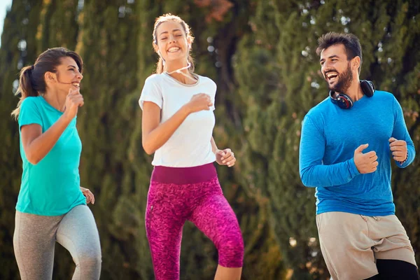 Jóvenes amigos corriendo juntos al aire libre viviendo un estilo de vida saludable activo —  Fotos de Stock