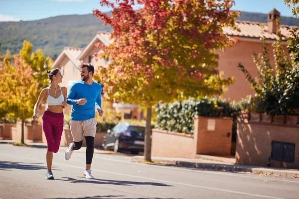 Un couple souriant qui fait du jogging. courir à la ville. mode de vie sain — Photo