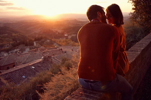 Улыбающиеся мужчина и женщина обнимаются и целуются на закате — стоковое фото