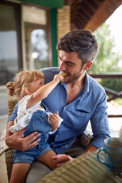 Kind heeft plezier tijdens het voeden vader — Stockfoto