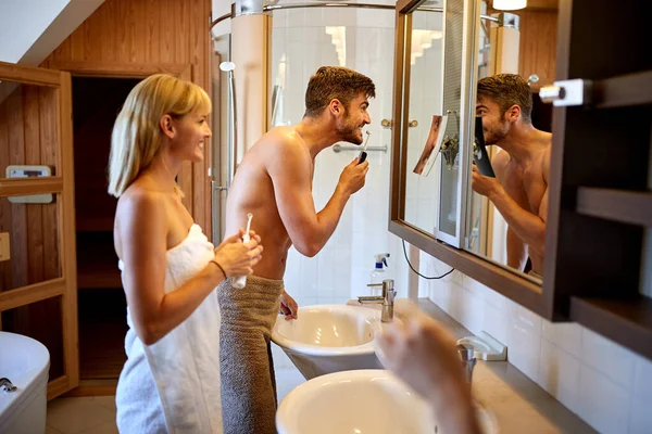 Couple in bathroom brushing teeth — Stock Photo, Image