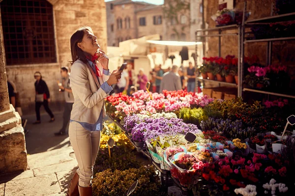 Zakenvrouw het kopen van bloemen bij de bloemenwinkel op straat — Stockfoto