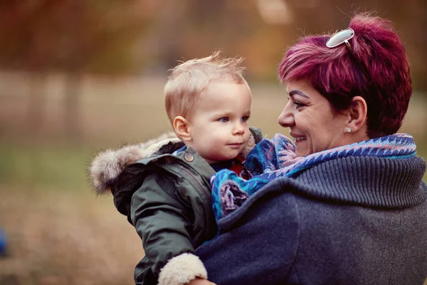 Ragazzo con madre al parco autunnale. Famiglia, infanzia, stagione — Foto Stock