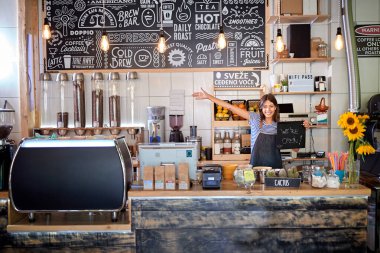 Kafe açık. Yeni açılan kafede çalışan bir kadın var.