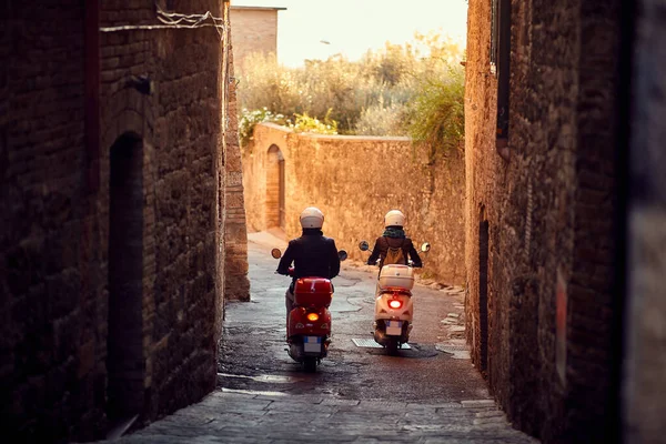 男人和女人在城里骑摩托车。马车夫在路上. — 图库照片