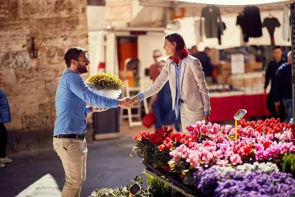 Женщина покупает цветы в цветочном магазине на улице . — стоковое фото