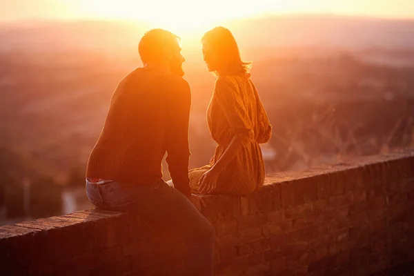 Lachende man en vrouw knuffelen en zoenen bij zonsondergang — Stockfoto
