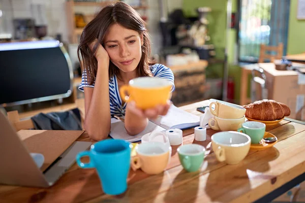 Kaffeaffärsidé.Kvinna väljer kaffemuggar. — Stockfoto