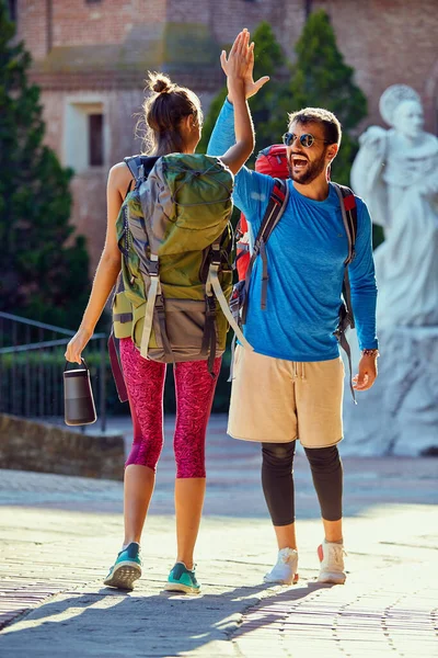 Casal sorridente com mochileiros andando e viajando ao ar livre — Fotografia de Stock