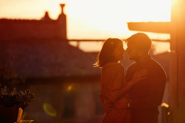 Cheerful couple kissing outdoor at the sunset — Stock Photo, Image