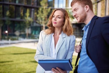 Erkek ve dişi iş arkadaşları dışarıda plan yapıyor ve tartışıyorlar.