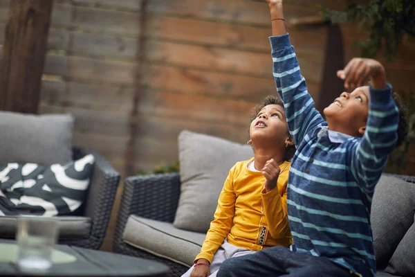 快乐的小男孩和小女孩一起坐在户外玩气球 — 图库照片