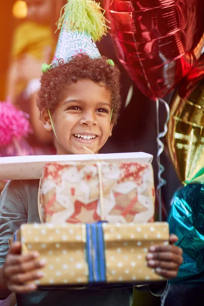 Χαρούμενο Χαριτωμένο Αγόρι Καπέλο Γενεθλίων Κρατώντας Ένα Σωρό Δώρα Γενεθλίων — Φωτογραφία Αρχείου