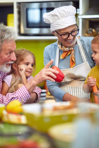 带着孩子在厨房做早餐的快乐祖父母 — 图库照片