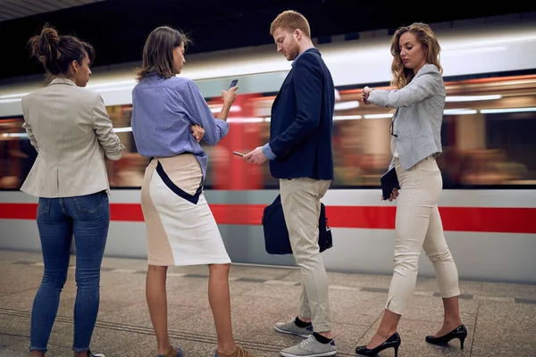 年轻的商人在看他们的手机 手腕手表 在地铁错过了火车 时间概念 — 图库照片