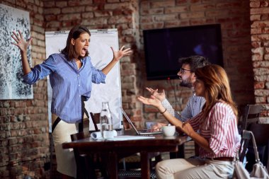 furious woman yelling with arms spread on a husband in cafe with another young female. rage, adultery, jealousy concept clipart