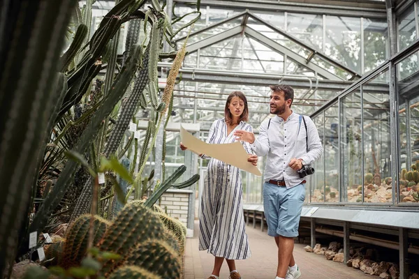 年轻的高加索游客带着不同种类的植物参观温室 植物园 — 图库照片