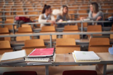 Kitaplar ve öğrenme materyalleri amfitiyatroda masanın üzerinde.