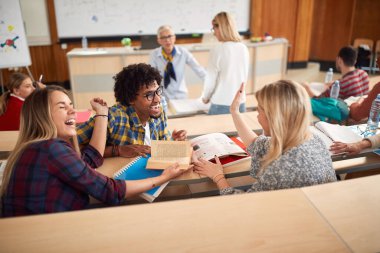 Öğrenciler amfitiyatroda ders verirken gülüyorlar