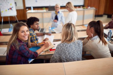 Amfitiyatroda derste gülümseyen mutlu kız öğrenci.;