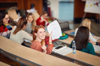 Kızıl saçlı mutlu kız öğrenci sınavı geçti.