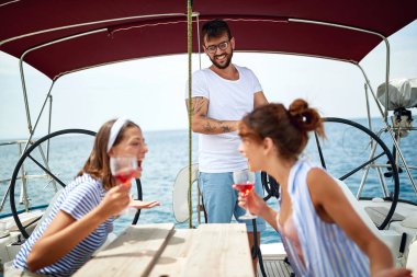 Yelkenlide gülümseyen ve kokteyl içen insanlar. - Yaz tatili