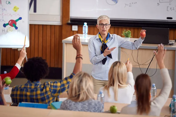 Elderly professor giving a lecture to students in amphitheater