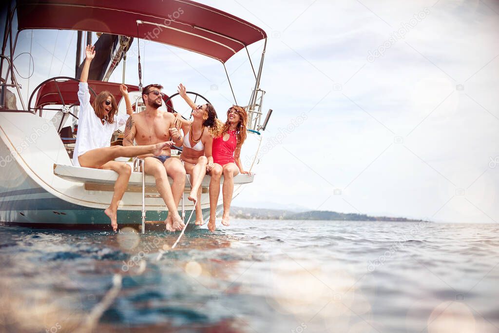 Smiling people sailing on yacht and enjoying. Vacation, travel, sea, friendship and people concept.
