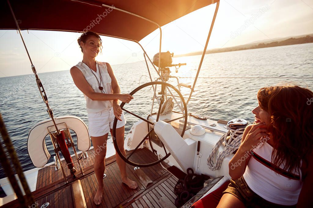 Happy woman enjoying on luxury boat at sunset on  vacation