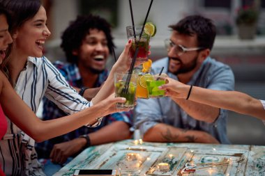 Bir grup neşeli genç gece partisi için kadeh kaldırıyor.