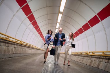 Metro istasyonundaki platforma yürüyen başarılı genç iş adamları.