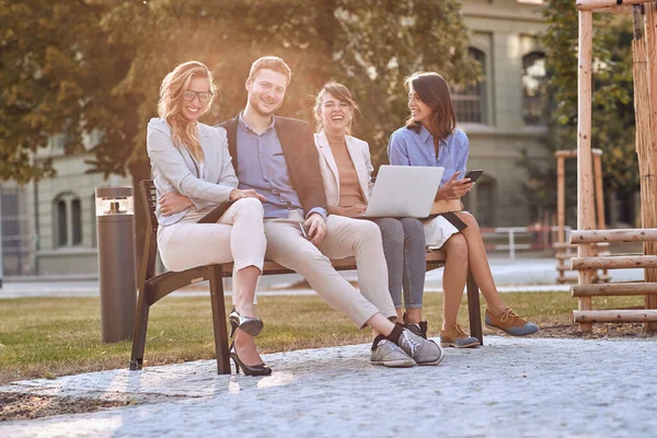 Unga Kaukasiska Vuxna Skrattar Bänken Park Med Sina Mobiltelefoner Laptop — Stockfoto