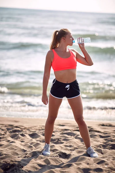 Ung Blond Fitness Kvinna Dricksvatten Vid Havet — Stockfoto
