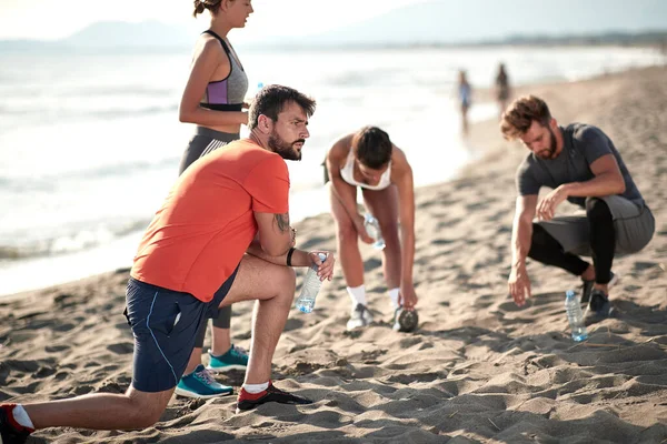 Grupo Jovens Está Aquecendo Antes Correr Praia Pelo Mar Estilo — Fotografia de Stock