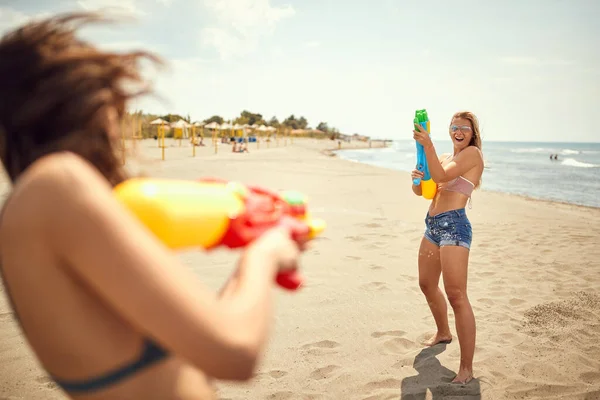 Duas Mulheres Caucasianas Aptas Brincar Com Pistolas Água Praia — Fotografia de Stock