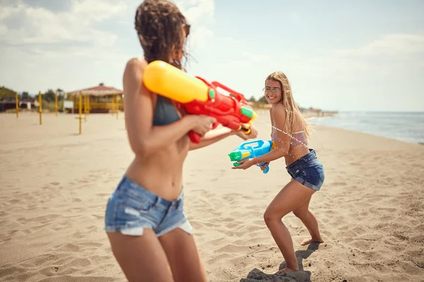 Blondynka Brunetka Bawią Się Pistoletami Wodnymi Piaszczystej Plaży — Zdjęcie stockowe