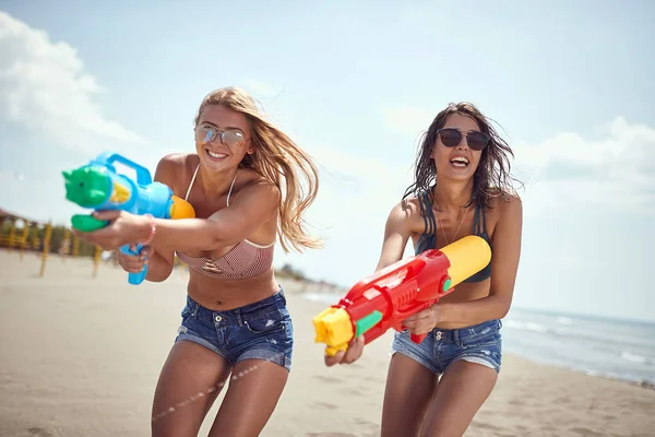 Güneş Gözlüklü Iki Güzel Seksi Kadın Kumlu Sahilde Tabancasıyla Oynuyorlar — Stok fotoğraf