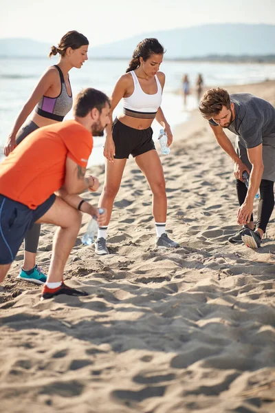 Grupo Hombres Mujeres Jóvenes Estirándose Calentándose Para Hacer Ejercicio Playa —  Fotos de Stock